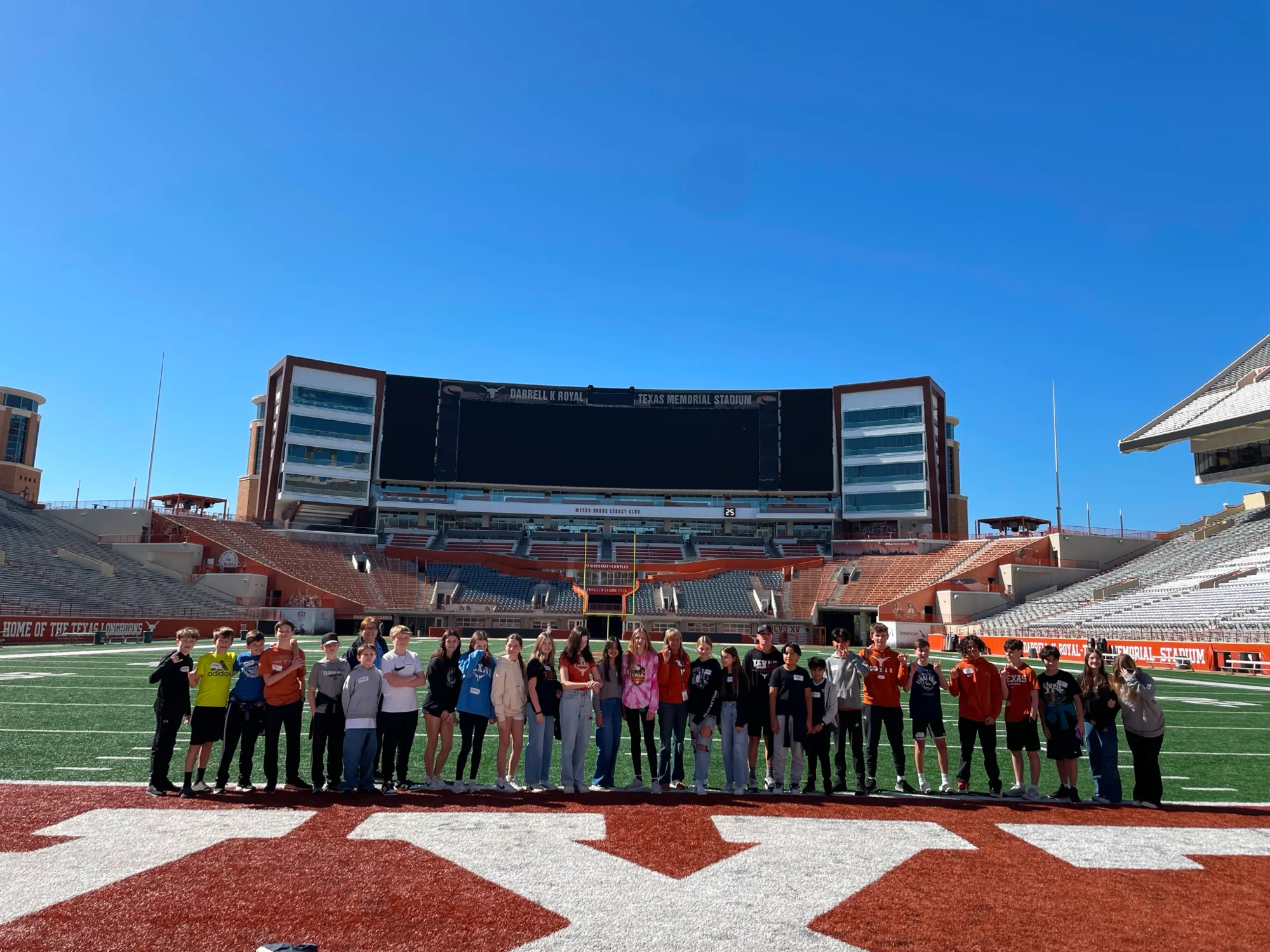 Austin ISD students standing on the field at UT Austin during a college campus visit
